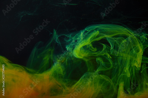 dark background with abstract green and orange swirls of paint