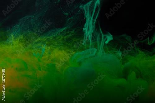 abstract background with green swirls of watercolor paint in water