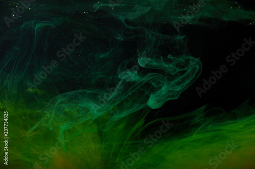 abstract background with green swirls of paint in water