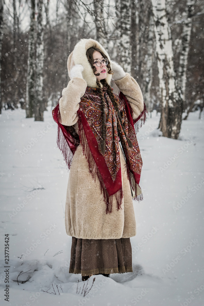 Girl in a fur coat on a walk in park and enjoying a winter day Girl in a fur coat on a walk in park and enjoying a winter day