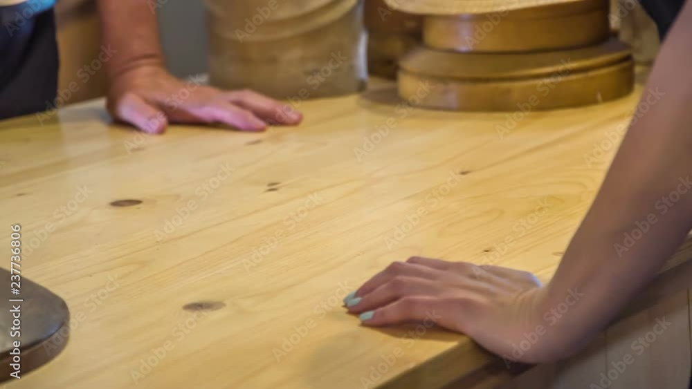 Two people are standing on two sides of the counter in a shop. One of them is a customer and the other one a man working in a shop. Two people are standing on two sides of the counter in a shop. One of them is a customer and the other one a man working in a shop.