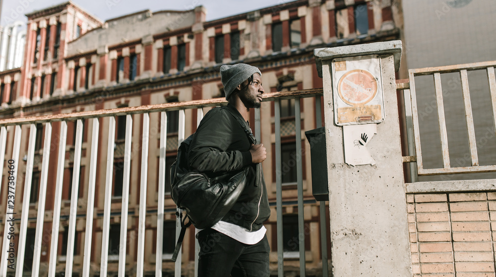 Young african american man walking by the city in a sunny day Young african american man walking by the city in a sunny day