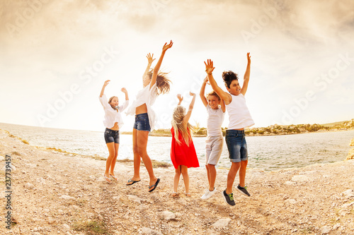 Excited teens jumping and having fun on the beach