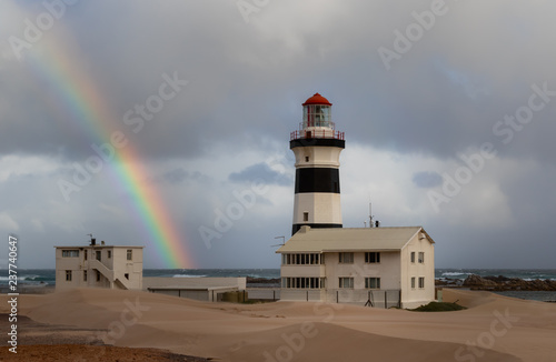 Cape Receife lighthouse near Port Elizabeth in South Africa with a rainbow in the sky