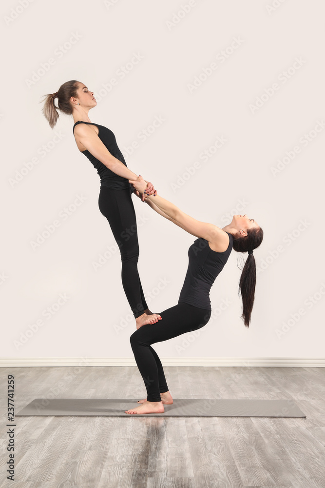 Two slim girls are doing yoga