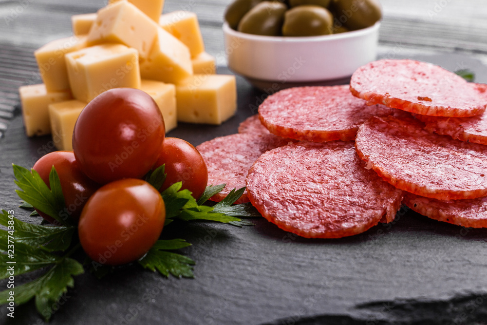 delicious sliced salami on a stone plate wooden background delicious sliced salami on a stone plate wooden background