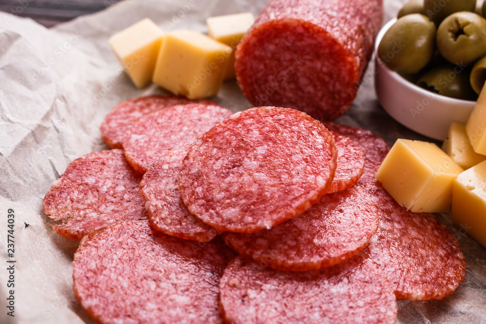 delicious sliced salami on a wooden background