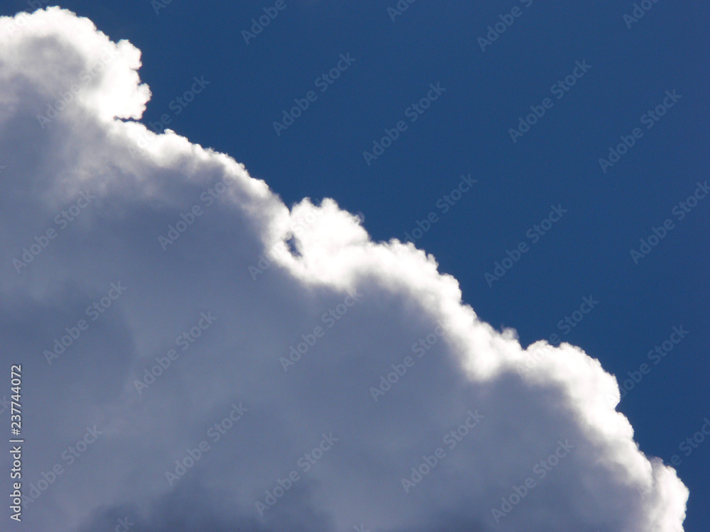 Against the blue sky the cloud is illuminated by the sun