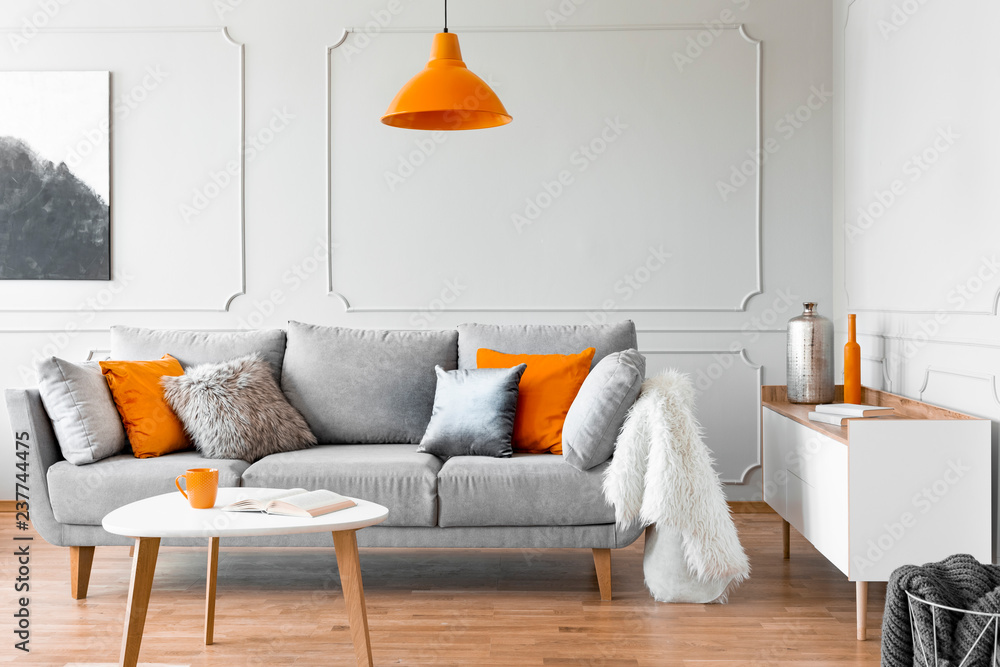Orange Lamp Above Table And Grey Settee