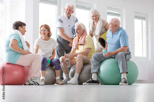 Low angle on happy elderly people on balls after gymnastic classes in the studio photo