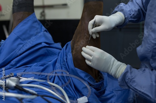 Female surgeon examining a horse in operation theatre photo