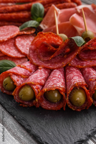 Cold smoked meat plate on a rustic wooden background