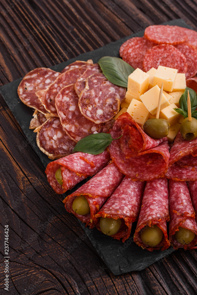 Cold smoked meat plate on a rustic wooden background Cold smoked meat plate on a rustic wooden background