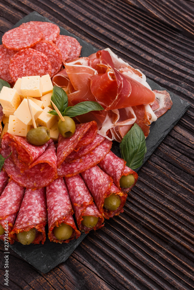Cold smoked meat plate on a rustic wooden background Cold smoked meat plate on a rustic wooden background