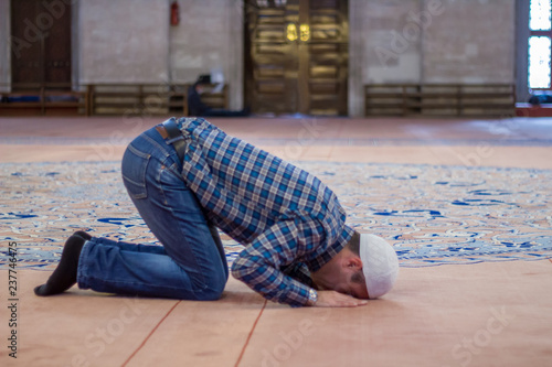 Young adult caucasian man praying and worship at the mosque