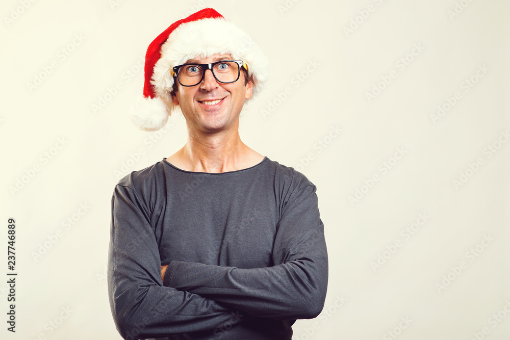Handsome man wearing glasses and a Christmas hat. Happy Santa man isolated on white, copy space. Carefree young man in glasses enjoying christmas time. People, christmas, sales and lifestyle concept Handsome man wearing glasses and a Christmas hat. Happy Santa man isolated on white, copy space. Carefree young man in glasses enjoying christmas time. People, christmas, sales and lifestyle concept