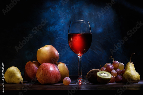 Still life, apples, grapes, fruit and red juice on a dark blue background. Diet, healthy eating.