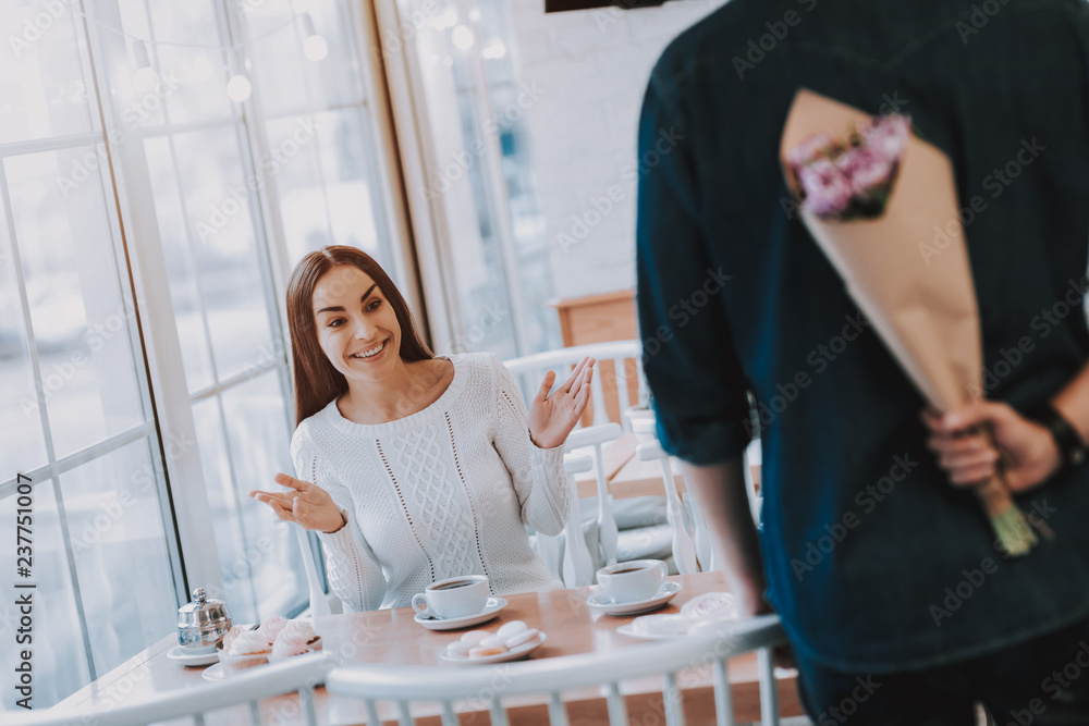 Obraz premium Man is Giving a Bouquet of Flowers to Woman