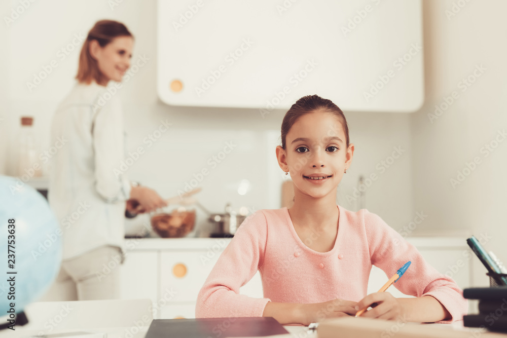 Mother Cooks On Kitchen. Daughter Does Homework. Mother Cooks On Kitchen. Daughter Does Homework.