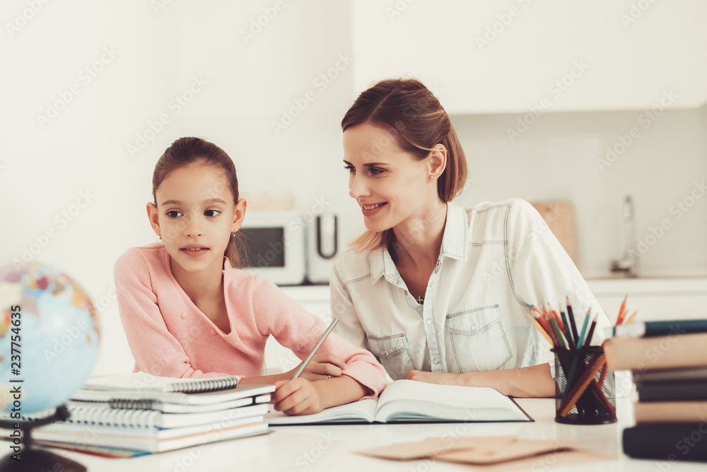 Mom Helps Daughter To Do Homework In The Kitchen. Mom Helps Daughter To Do Homework In The Kitchen.