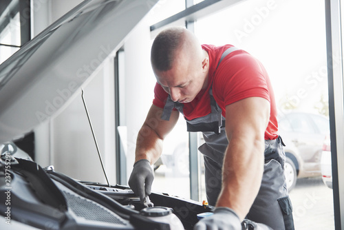 Auto mechanic working in garage. Repair service.