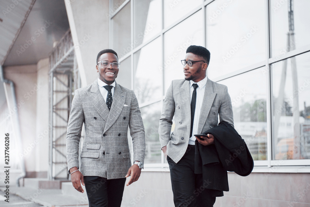 Business communication. Two cheerful business men talking to each other and discussing a project Business communication. Two cheerful business men talking to each other and discussing a project