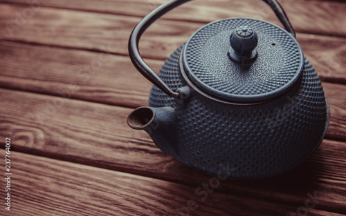 Old iron teapot on a wooden table.