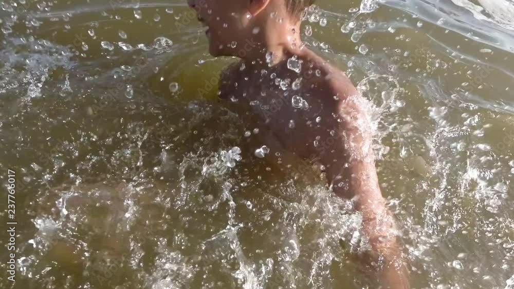 Happy little boy making splashes in water. Child having fun in the lake. Happy little boy making splashes in water. Child having fun in the lake.