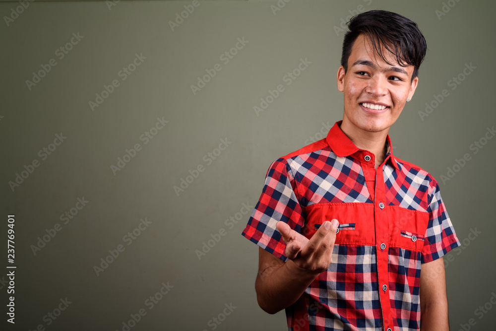 Young handsome Indian man against colored background Young handsome Indian man against colored background
