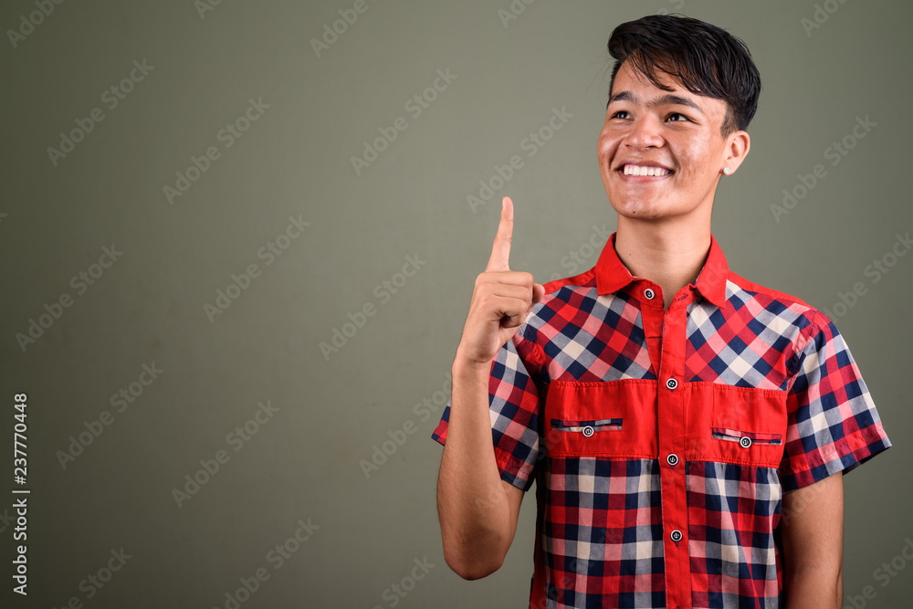 Young handsome Indian man against colored background Young handsome Indian man against colored background