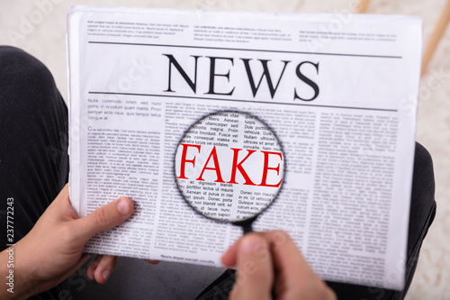 Photography Man Examining Fake News On Newspaper
