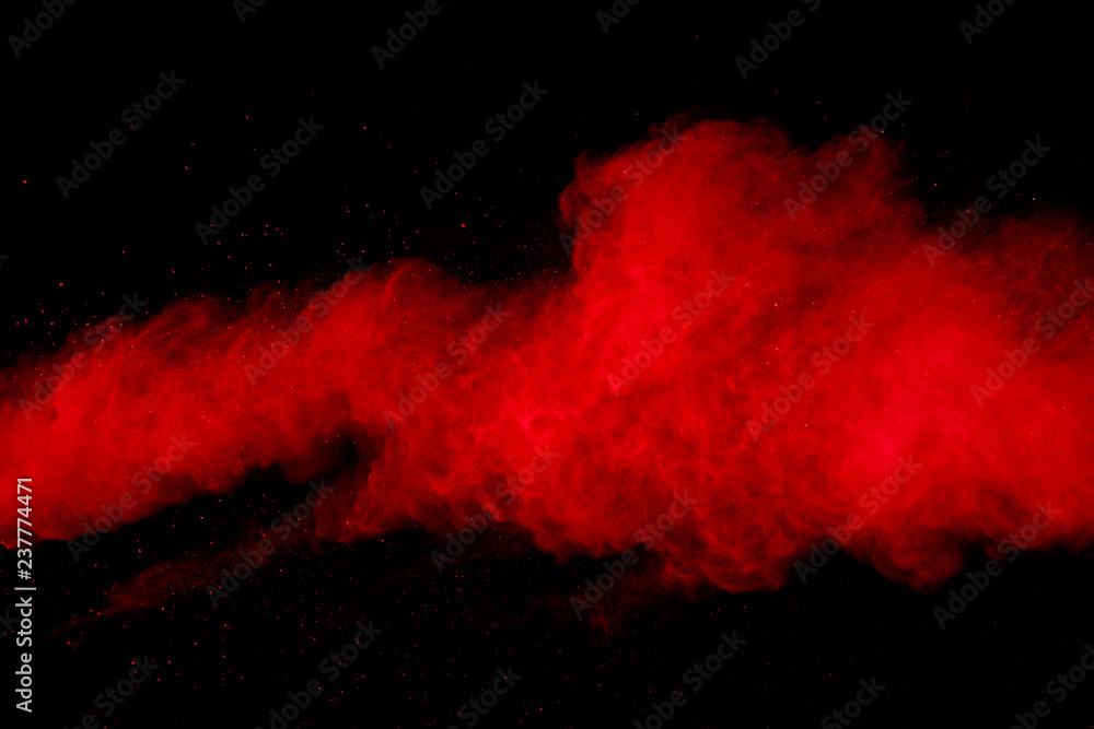 abstract red powder explosion on black background.abstract red powder splatted on black background. Freeze motion of red powder exploding.