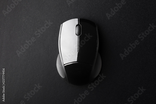 Black Wireless Optical Mouse on Black Surface Seen from Above