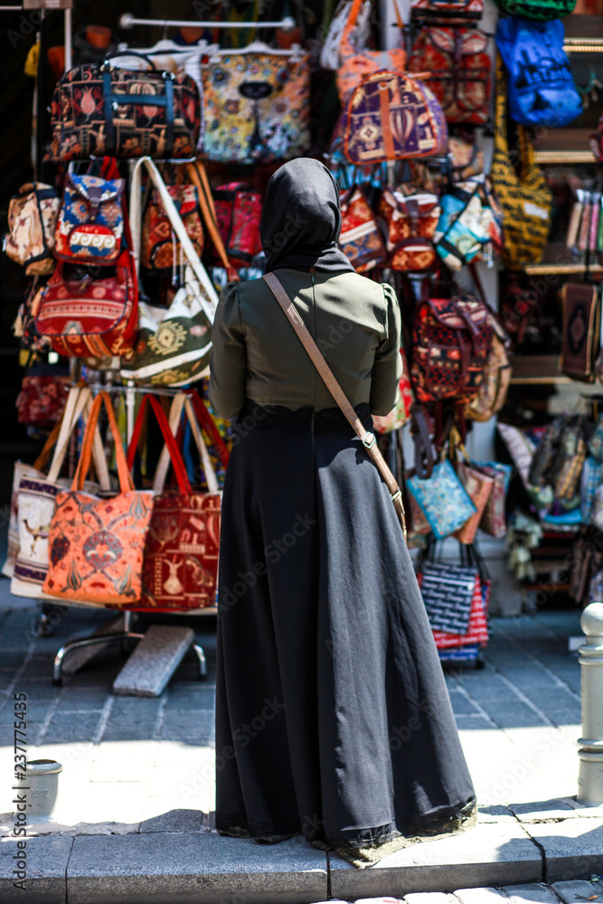 the woman in front of shop window with shopping bags