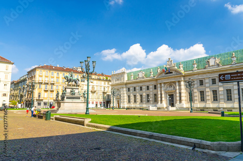 Biblioteca Nazionale National Library rococo style building on Piazza Carlo Alberto square with green lawn in historical centre of Turin Torino city with blue sky background, Piedmont, Italy