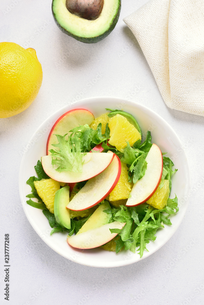 Fruit vegetable salad with red apples, avocado, orange slices Fruit vegetable salad with red apples, avocado, orange slices
