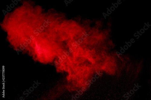 abstract red powder explosion on black background.abstract red powder splatted on black background. Freeze motion of red powder exploding. © wooddy7