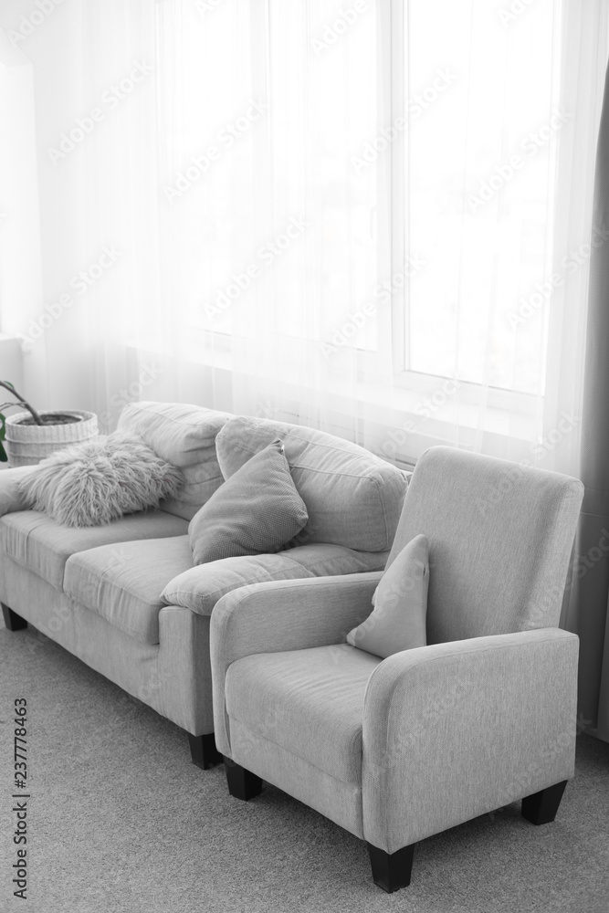 sofa with pillows. couch and chair. gray sofa next to the window. interior of the room sofa with pillows. couch and chair. gray sofa next to the window. interior of the room