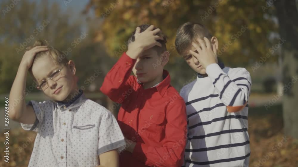 Three boys posing at the camera and straightes hair outdoors. Boys spend time together. Three boys posing at the camera and straightes hair outdoors. Boys spend time together.