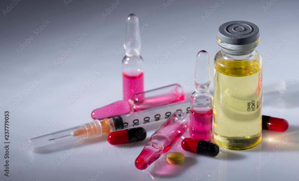 Medical piggers, a syringe, and a bottle of the drug on a light background Medical piggers, a syringe, and a bottle of the drug on a light background