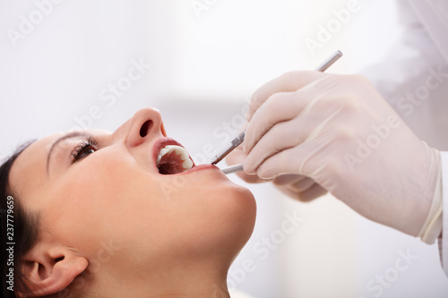 Female Patient's Teeth Being Checked By Dentist