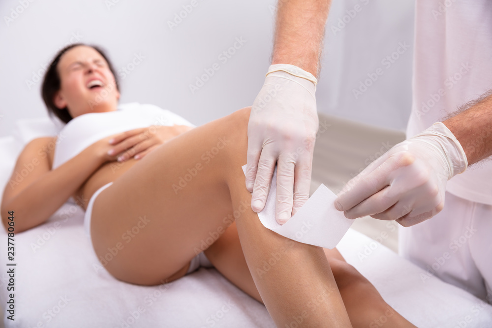 Fototapeta premium Therapist Waxing Woman's Leg