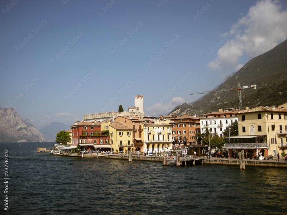 Lake Garda with sunning landscape and a colorful house scenic view to water and mountains