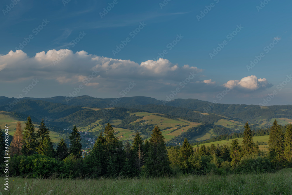Evening in national park Pieniny with sunny shine over green meadows