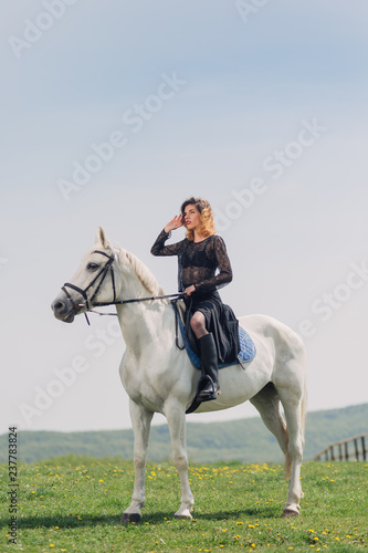 Young woman in black dress with her white horse outdoor © chrisgraphics