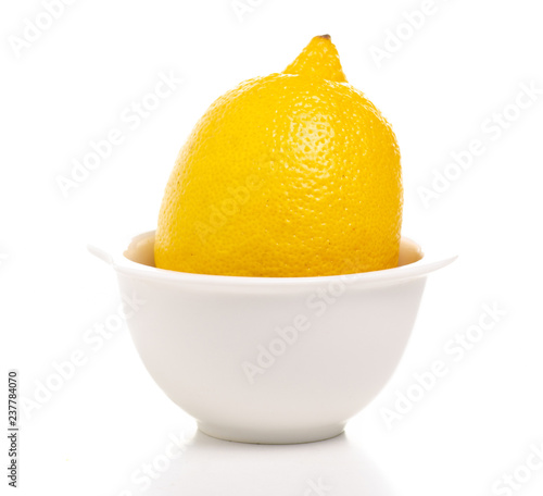 Lemon in white bowl in hand on white background isolation