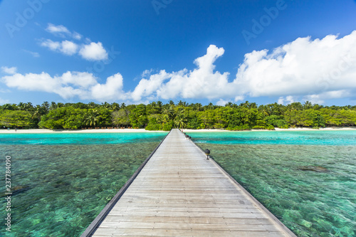 Sch  ner Holzsteg mit Blick auf eine Malediven Insel
