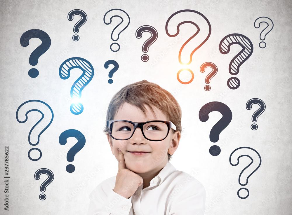 Thinking little boy, question marks on wall Thinking little boy, question marks on wall