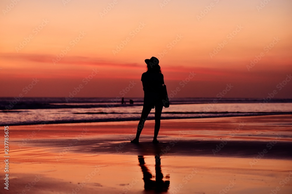 Tourist girl enjoying the sunset in Kuta Beach, Balı Island, Indonesia