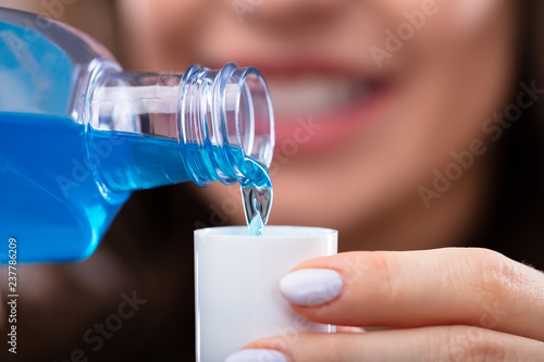 Woman Pouring Mouthwash Into Cap photo